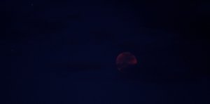 Roter Mond hinter Wolken
